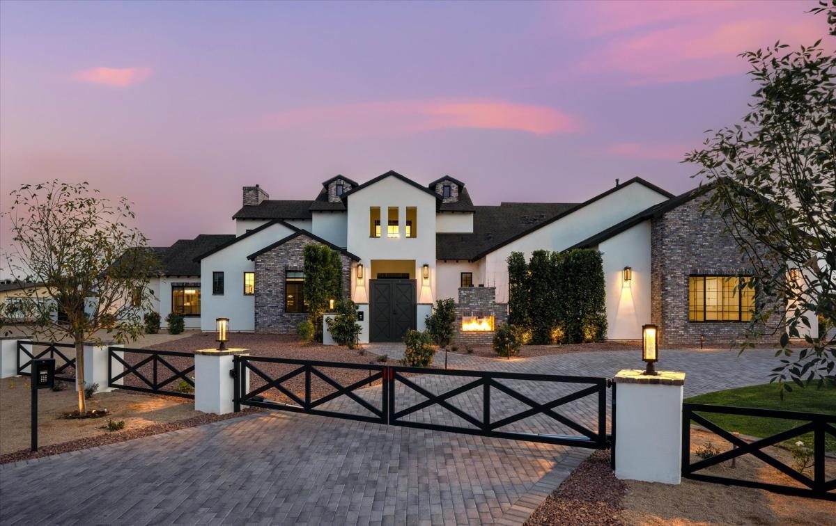 Modern farmhouse at dusk, built by Bel Aire
