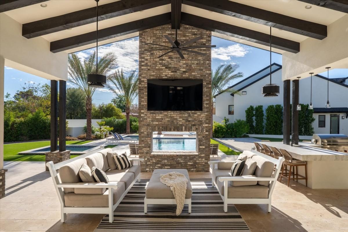 Covered patio with stone fireplace, built by Bel Aire